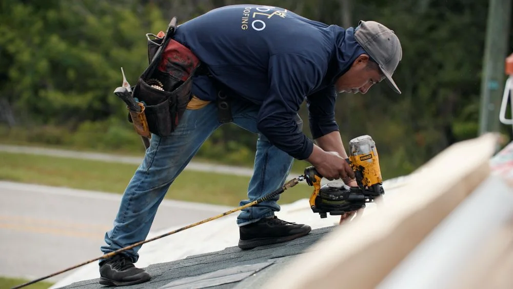 Manolo Roofing installer fastening shingles on a residential roof